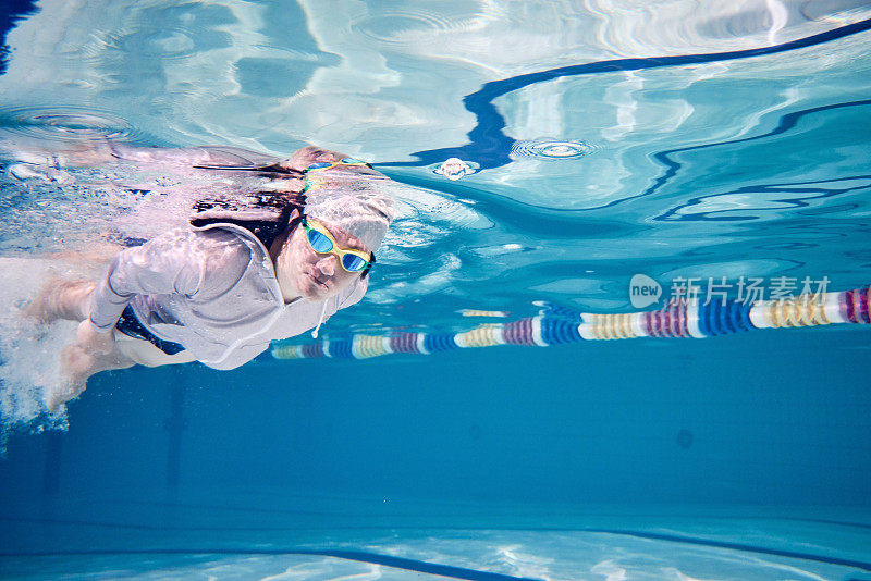 Male swimmer swimming underwater in a pool